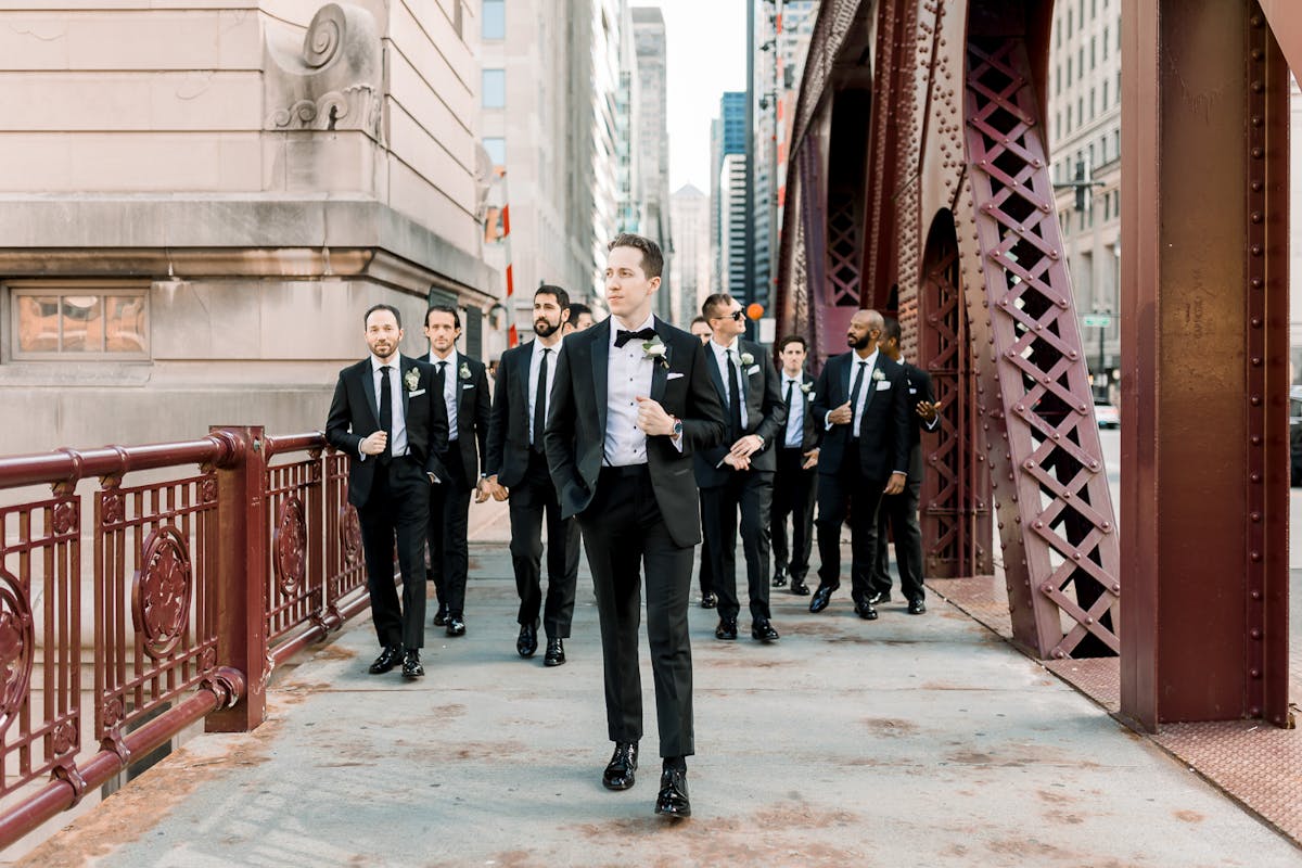 Grooms men walking across downtown chicago bridge