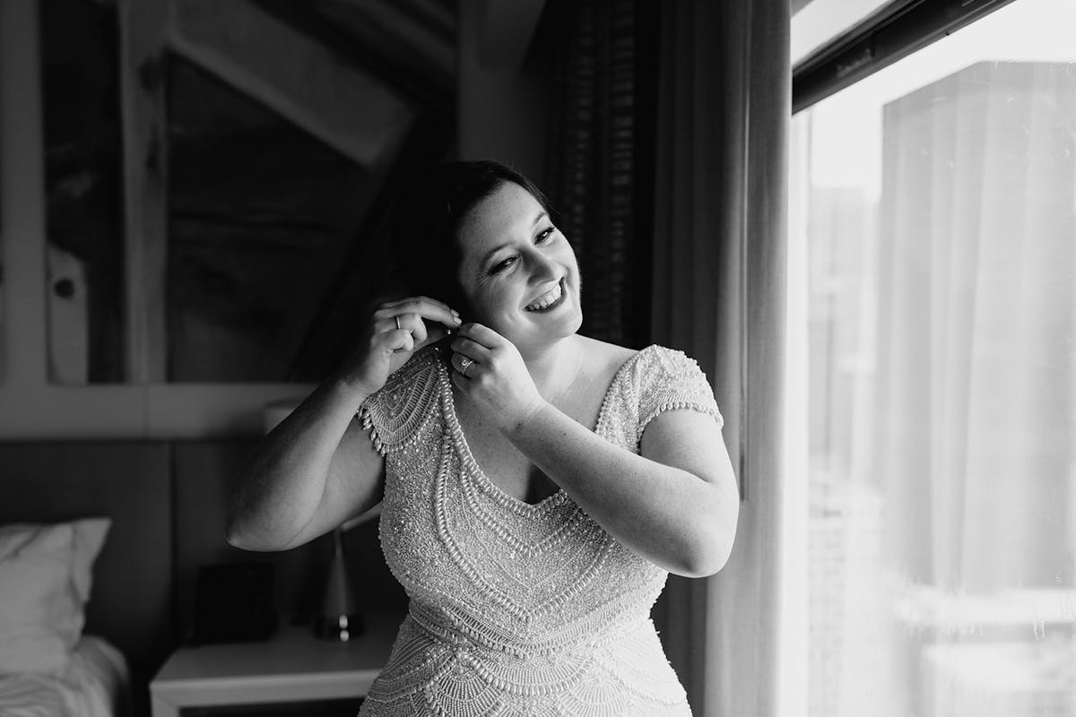 a woman brushing her hair in front of a mirror posing for the camera