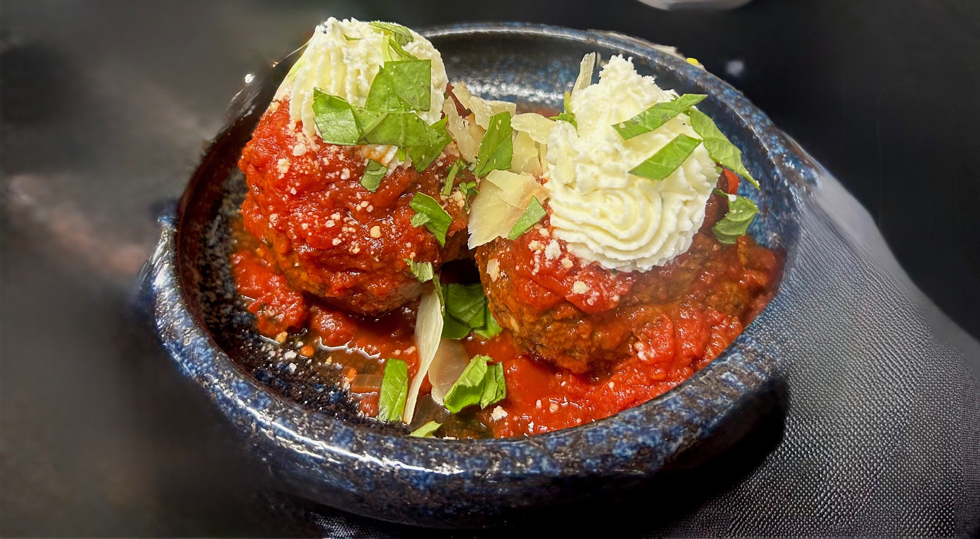 a bowl of food with sauce and cheese