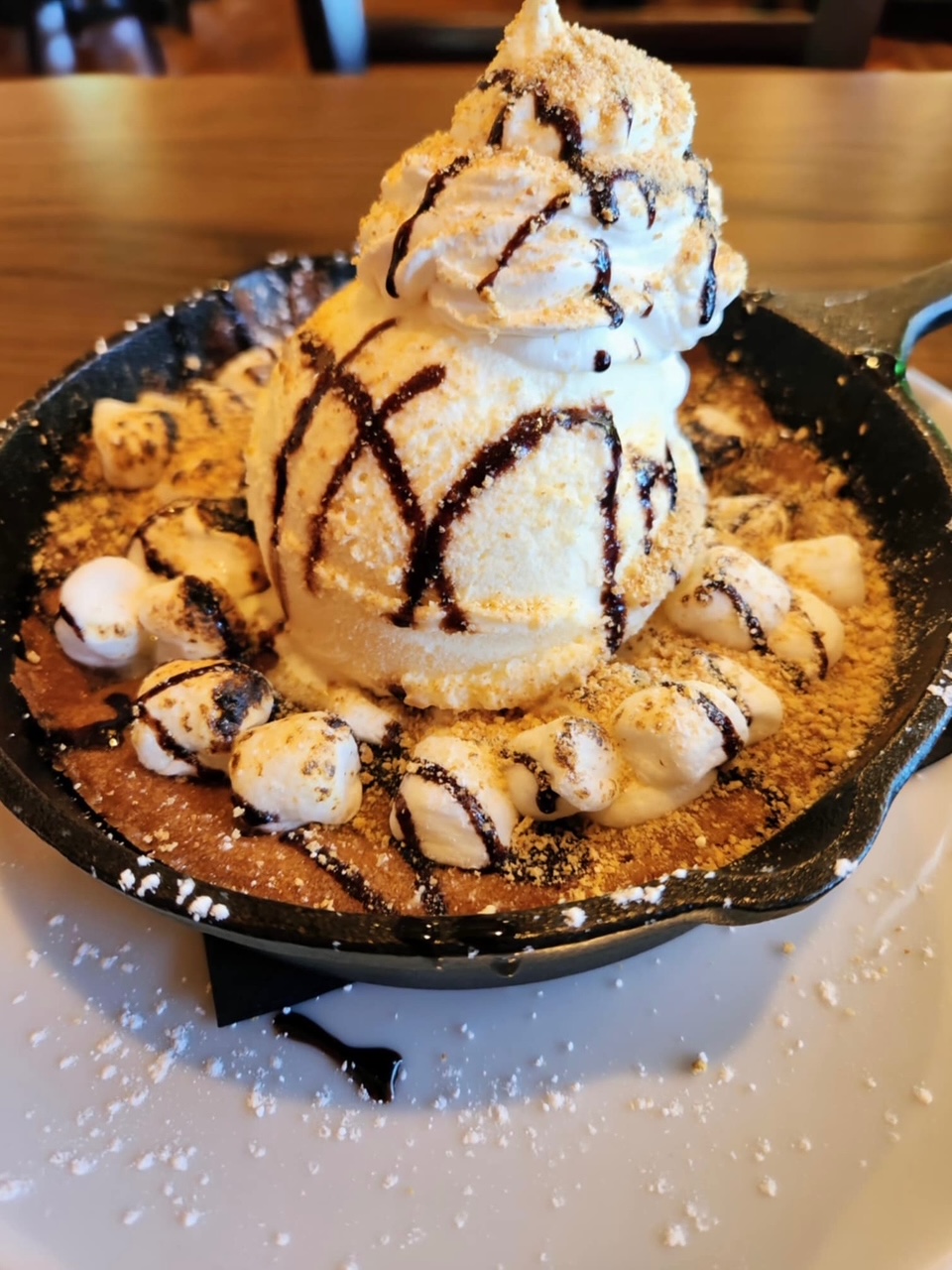 a skillet with a scoop of ice cream and chocolate drizzle