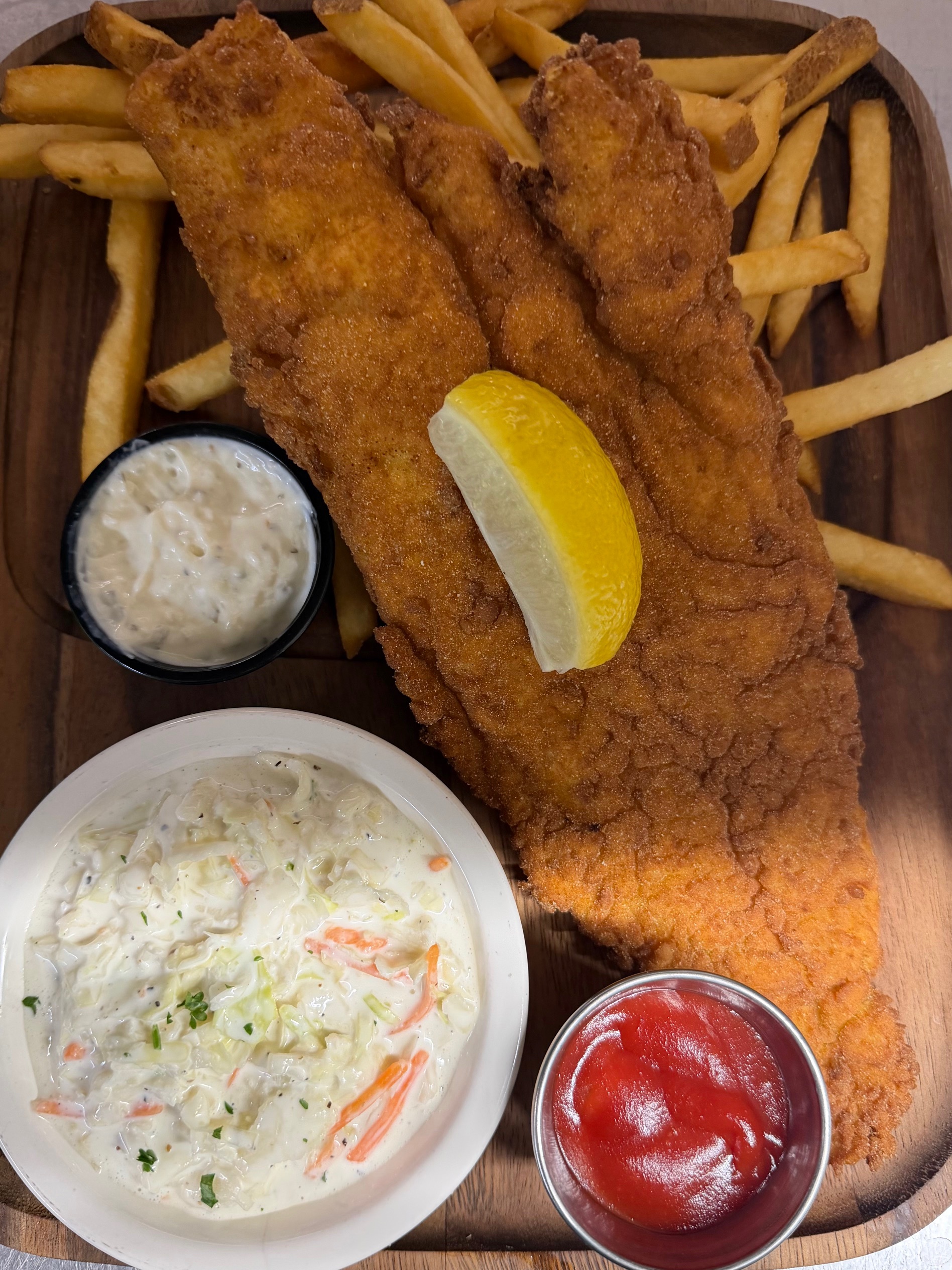 a plate of fried fish and fries with sauces