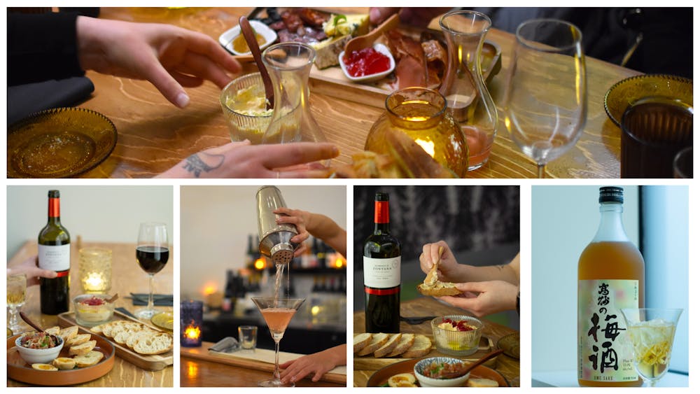a woman sitting at a table with food and a bottle of wine