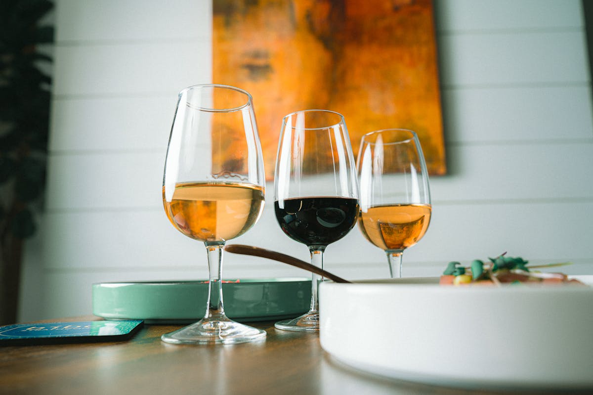 a glass of wine sitting on top of a wooden table