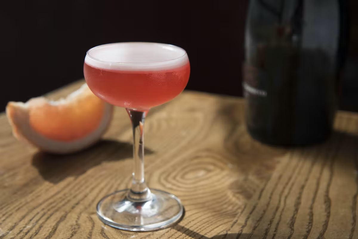 a glass of wine sitting on top of a wooden table