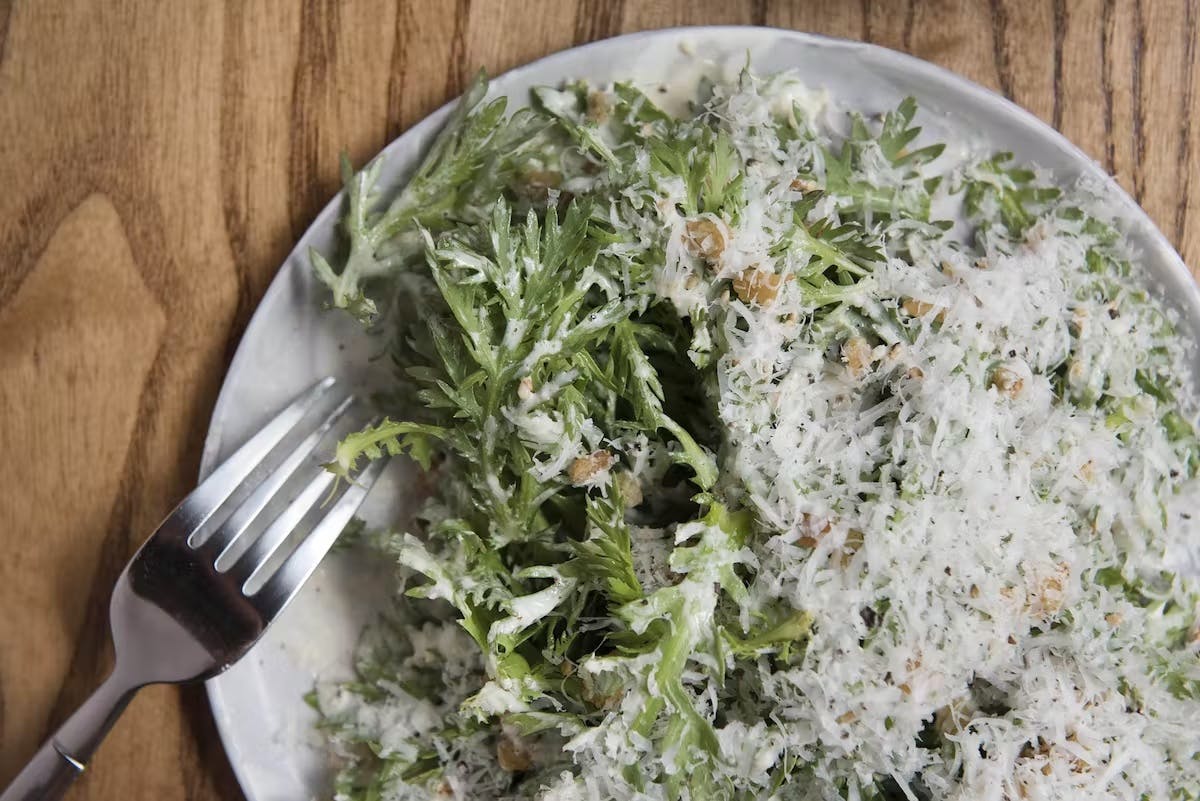 a bowl of salad and a fork on a plate