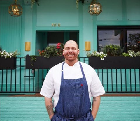 a man in a blue shirt standing in front of a building