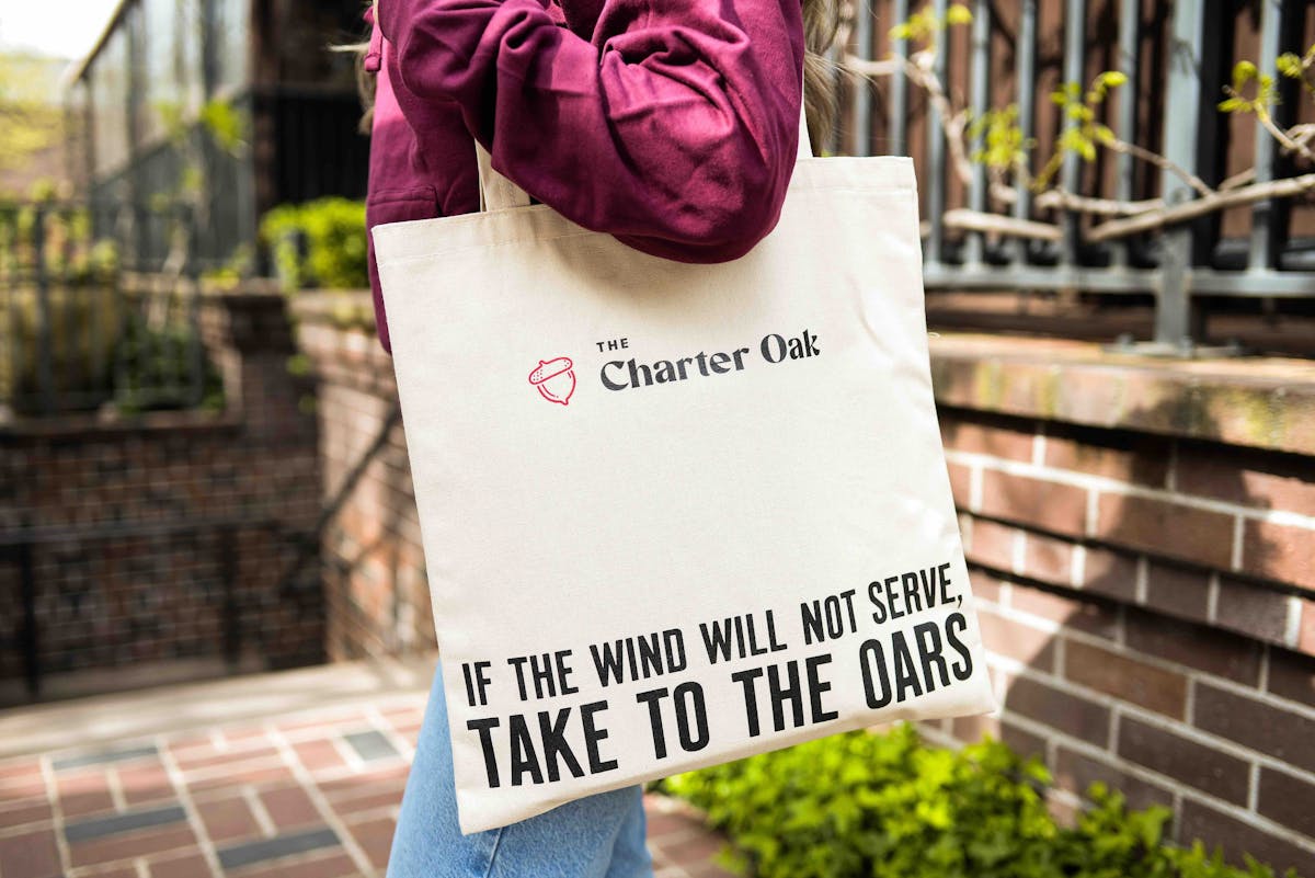 employee holding tco acorn tote