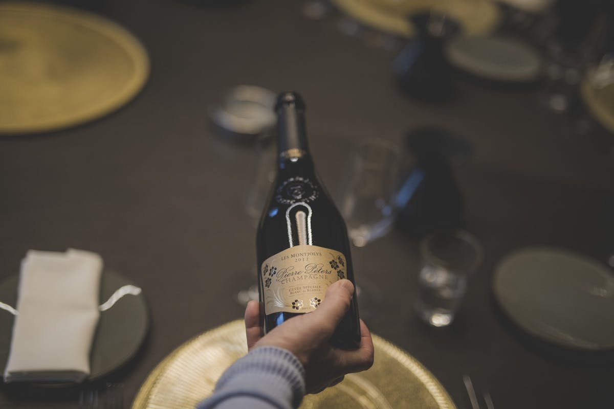 a hand holding a bottle of wine
