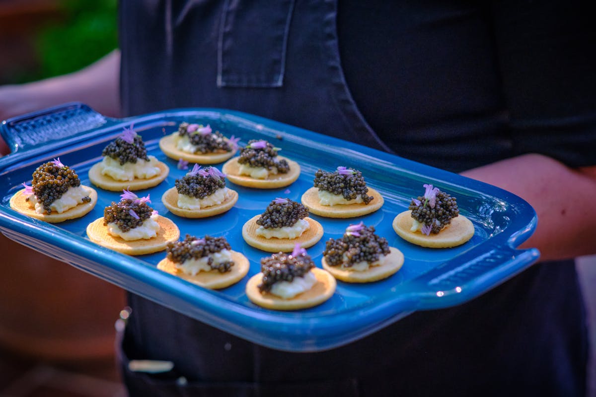 a tray of charter oak canapes topped with edible flowers