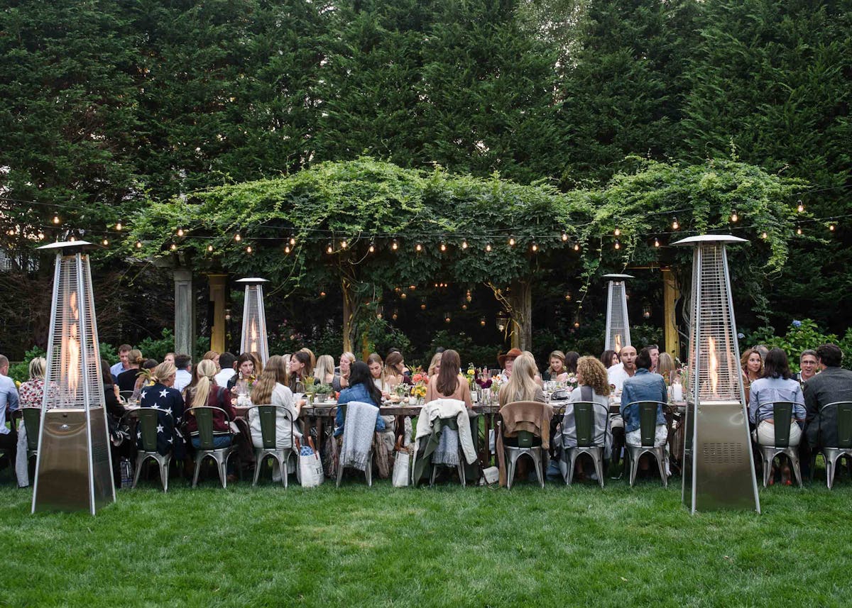 a wedding catered by the charter oak with guests enjoying food around a long family-style table