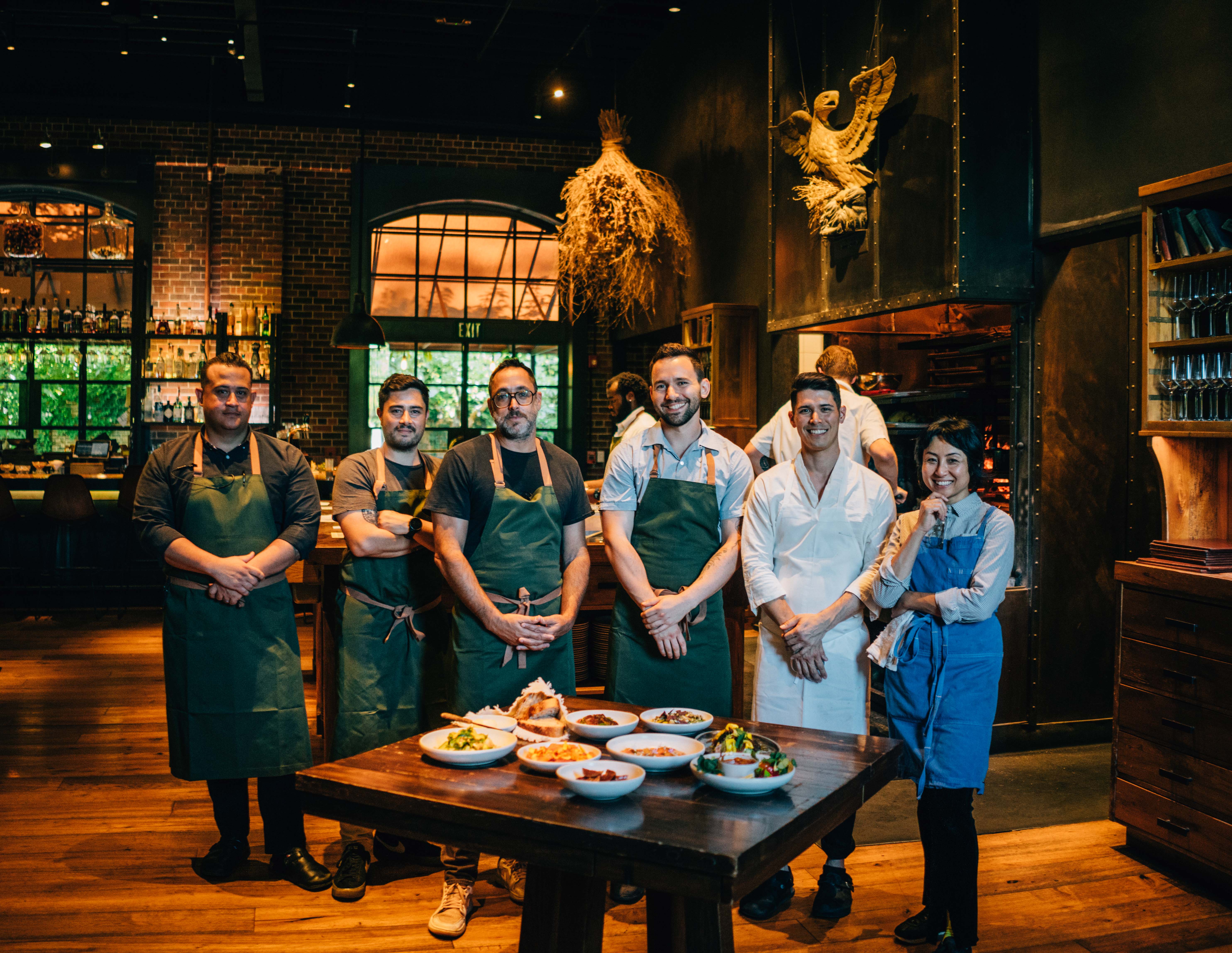 a group of people standing around a table