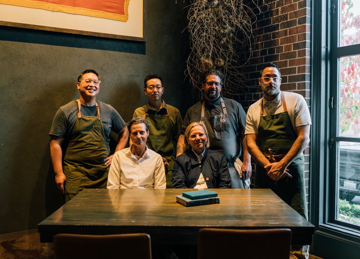 group of chefs standing behind a table in the charter oak dining space