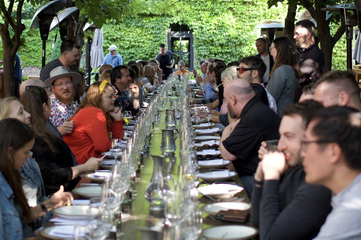 a large group of people sitting at a long table