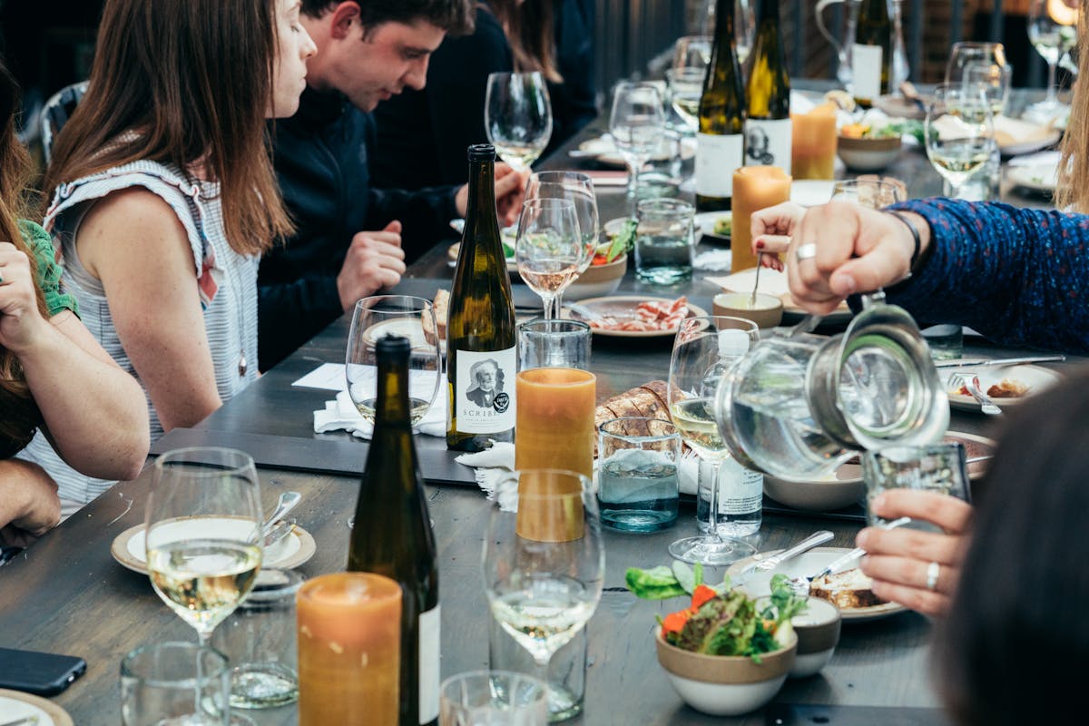 a group of people sitting at a table with wine glasses