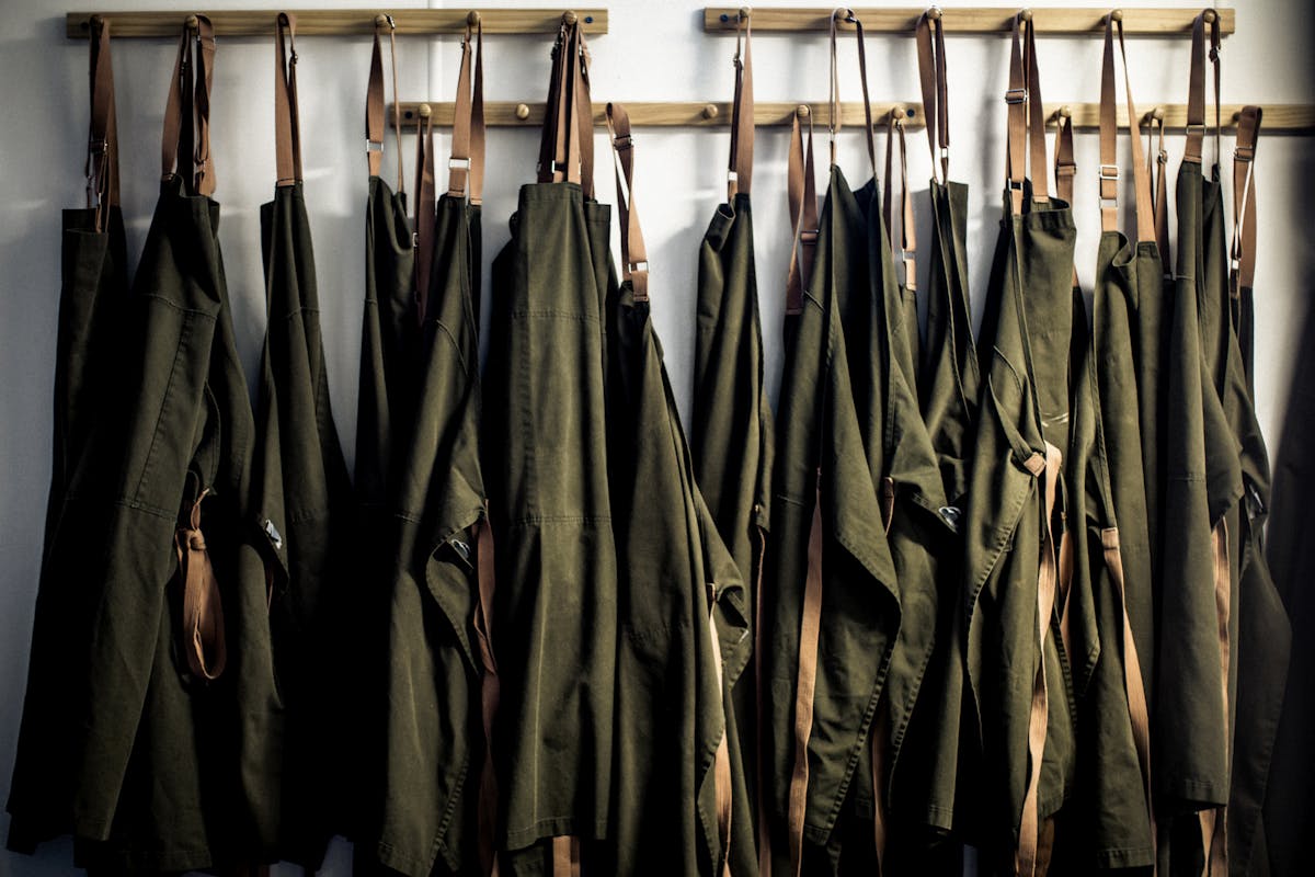 a bunch of aprons hanging on a wall