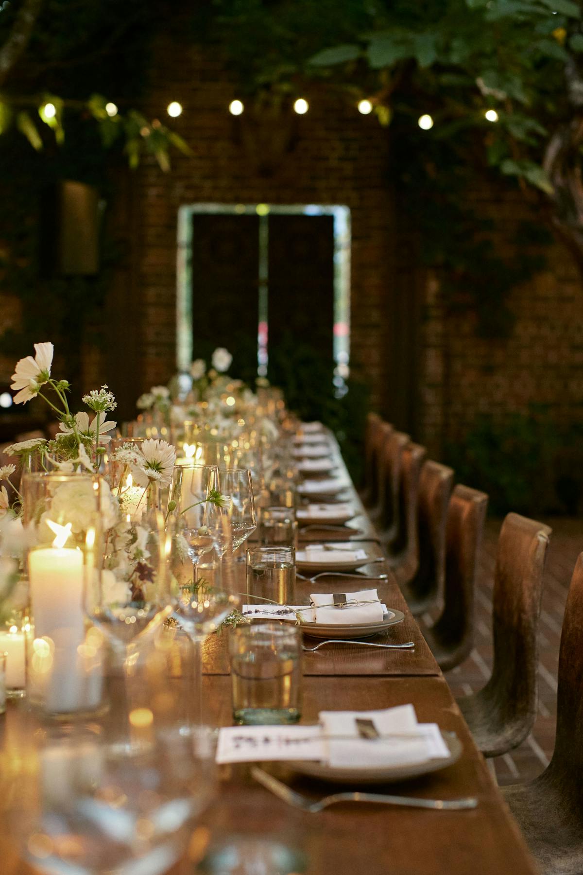 a long shot of a charter oak table with wine glasses and bouquets of flowers