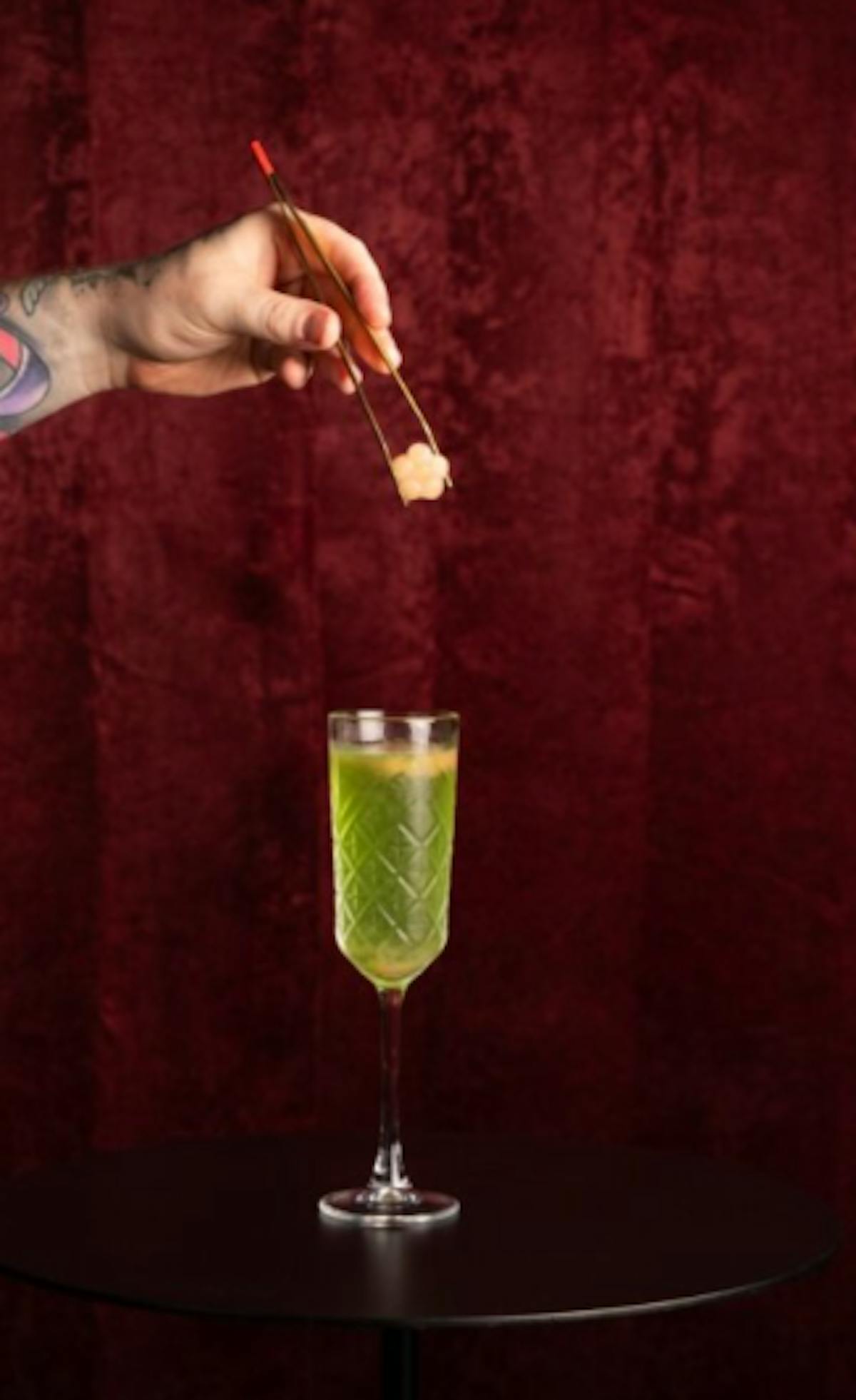 Hand dropping sugar cube in Chartreuse