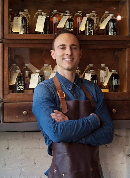 headshot of man in apron and long sleeve collared shirt