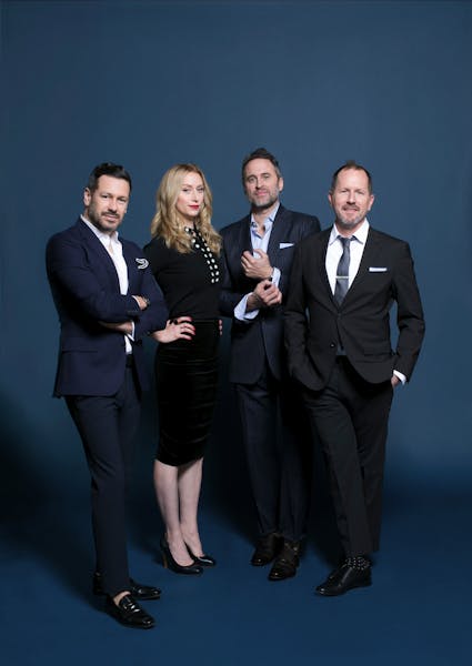 portrait of three men and one woman in business attire
