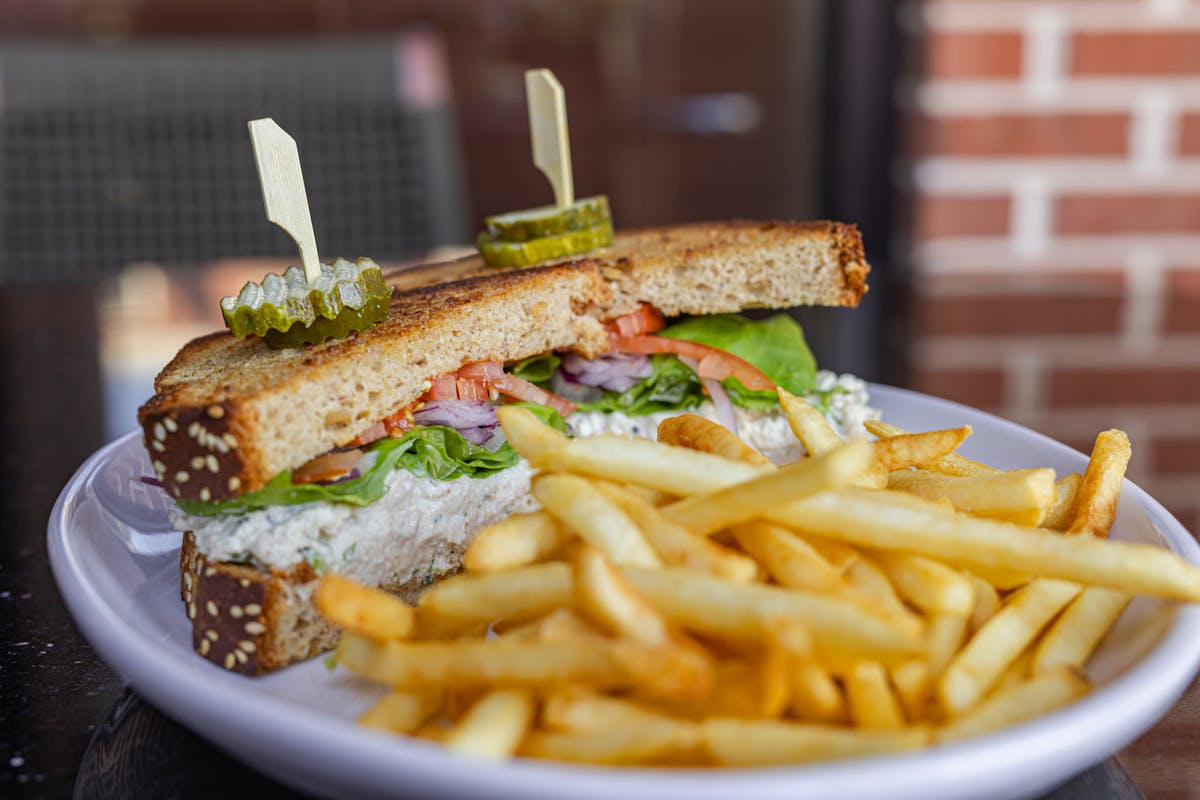 a close up of a sandwich and fries on a plate