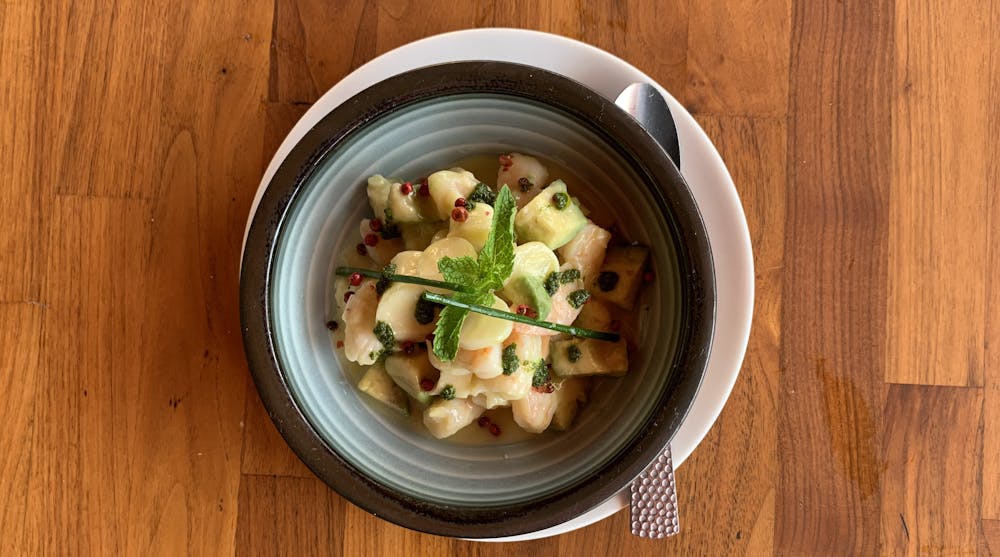 a bowl of food sitting on top of a wooden table