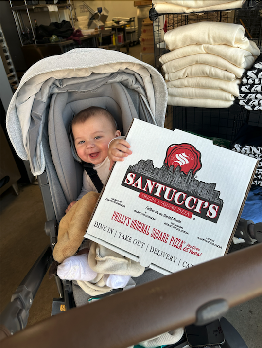 Baby Frankie Santucci holding a pizza.