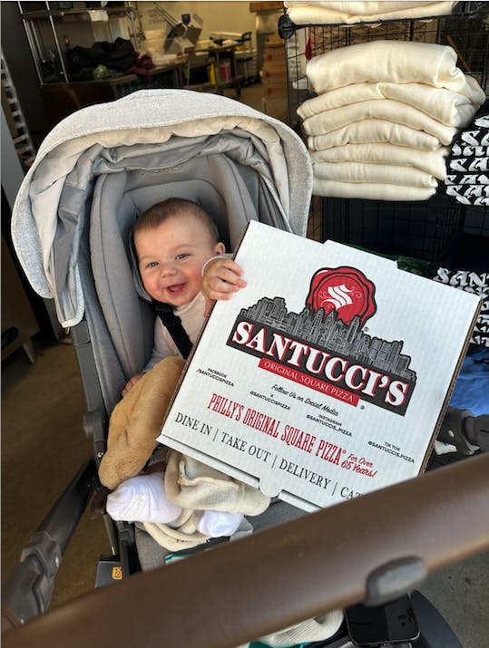 Baby Frankie Santucci holding a pizza.