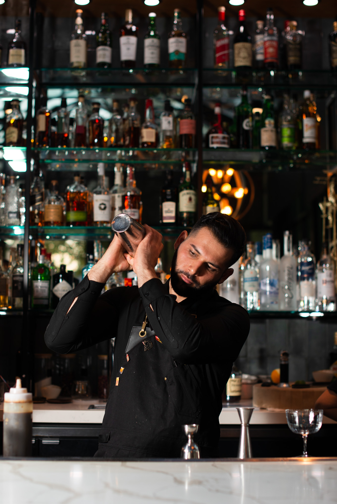 a man standing next to a bottle of wine