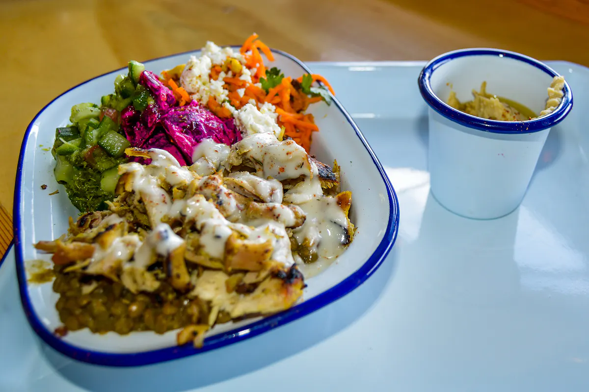 a plate filled with meat and some greens next to it
