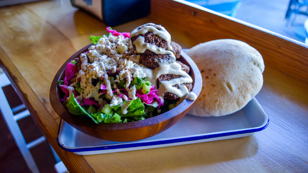 a wooden bowl filled with a greens salad