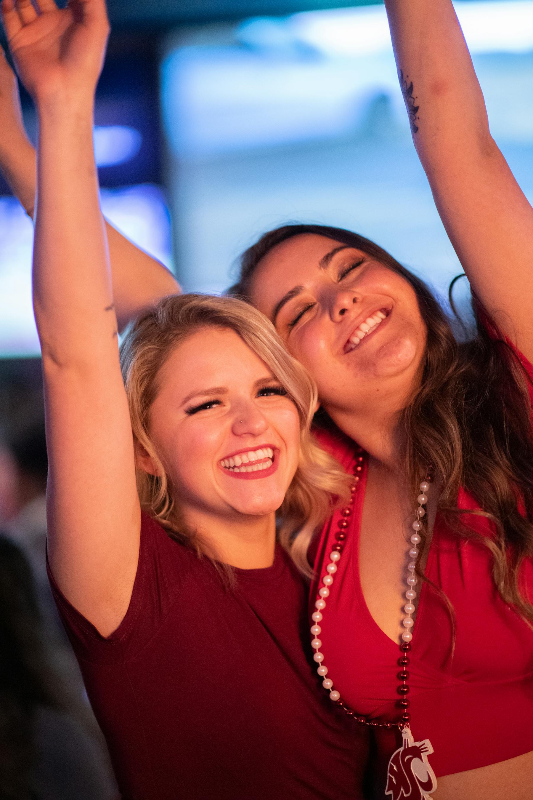 two women raising their arms celebrating