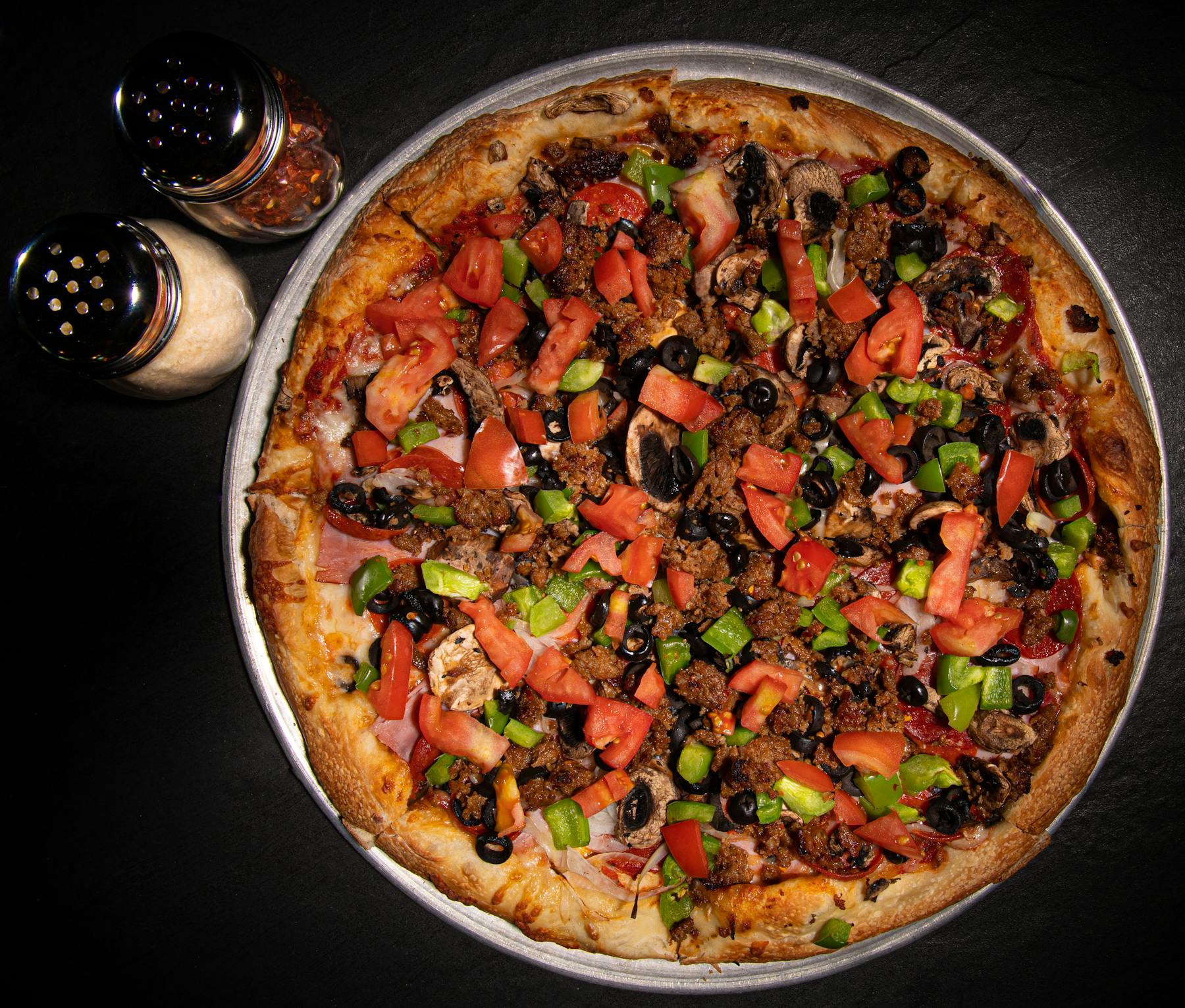a large pizza topped with lots of vegetables on a table