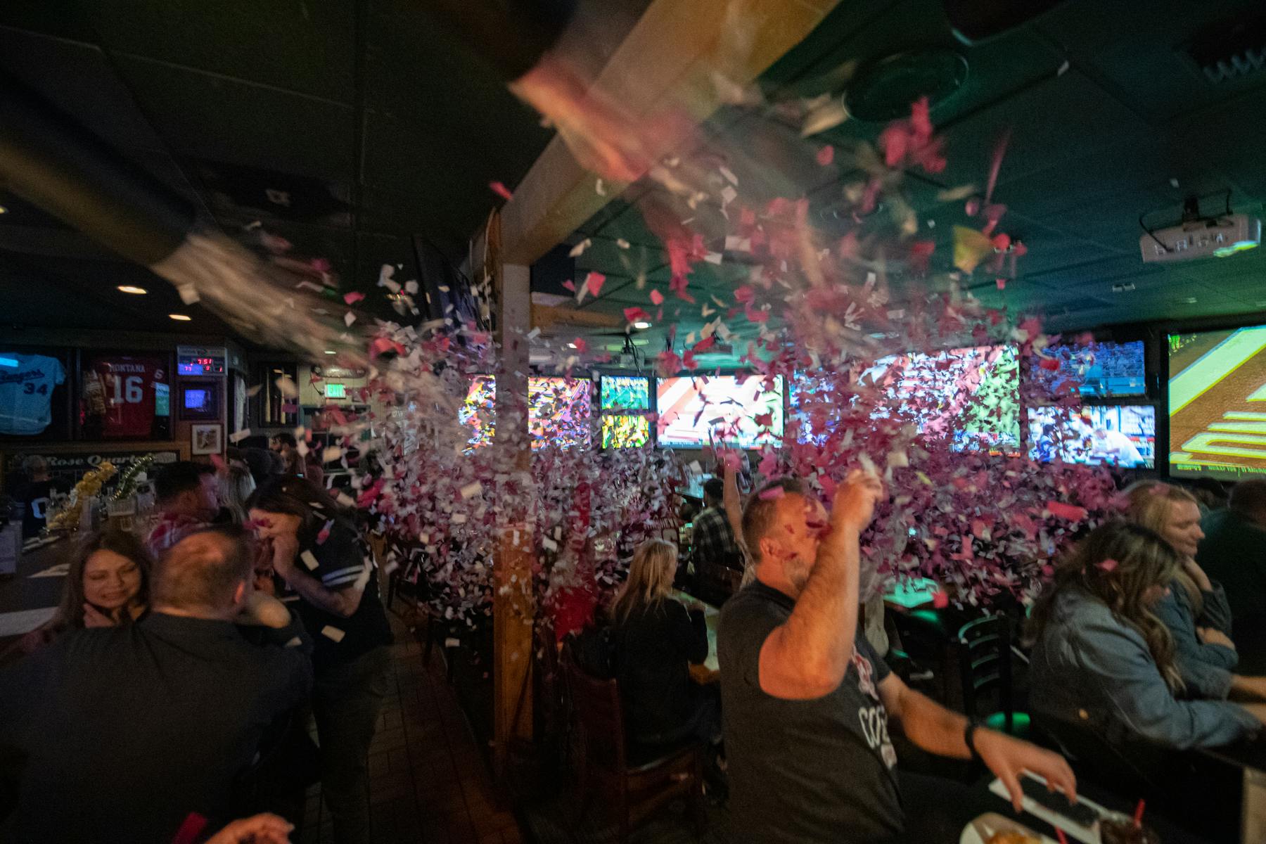 a group of people celebrating at the restaurant throwing confetti