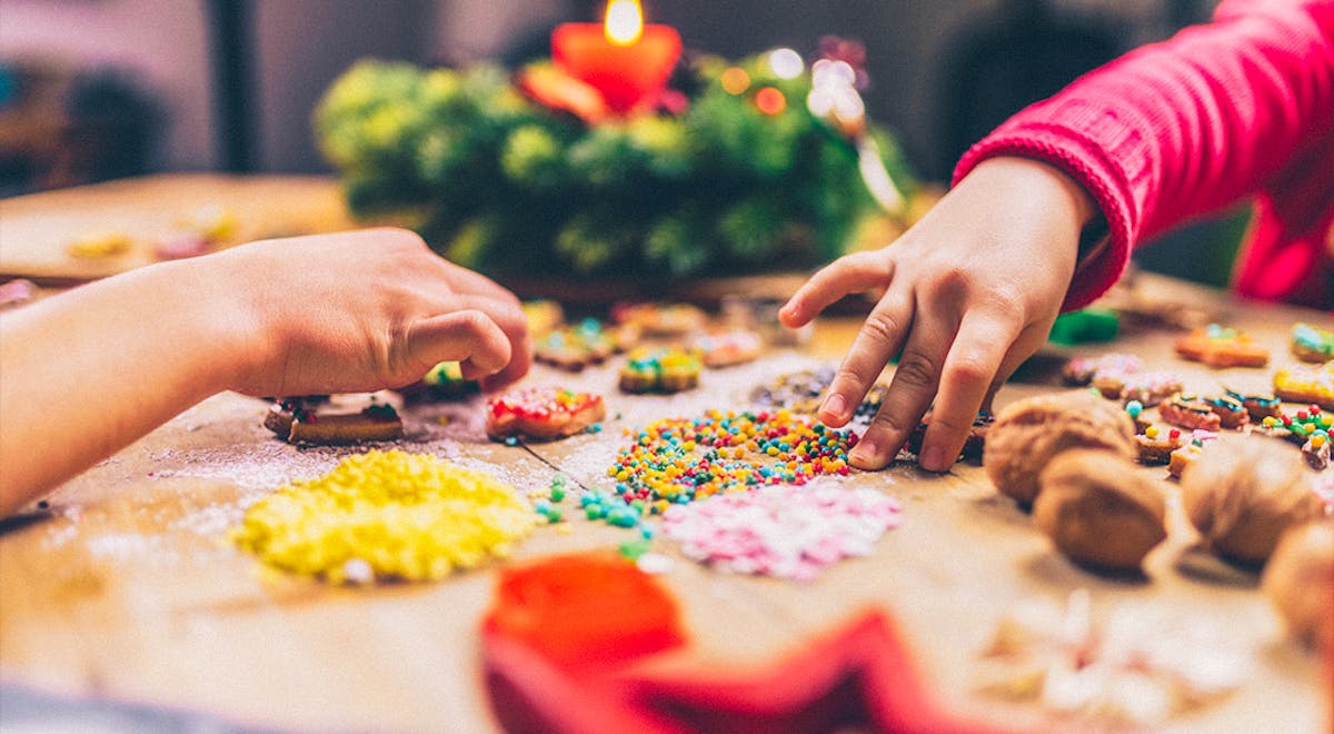 a person cutting up a birthday cake