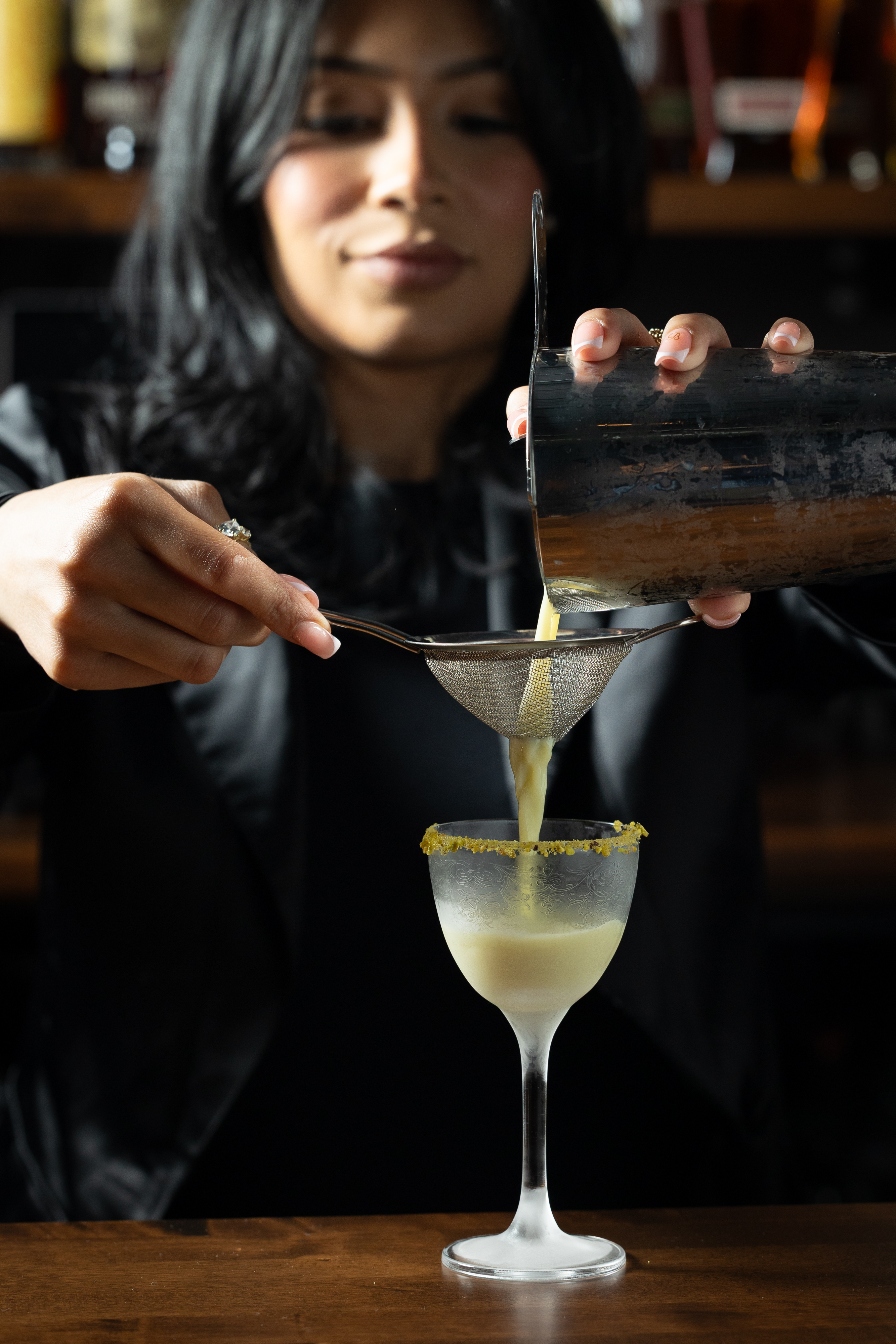 a woman pouring liquid into a glass