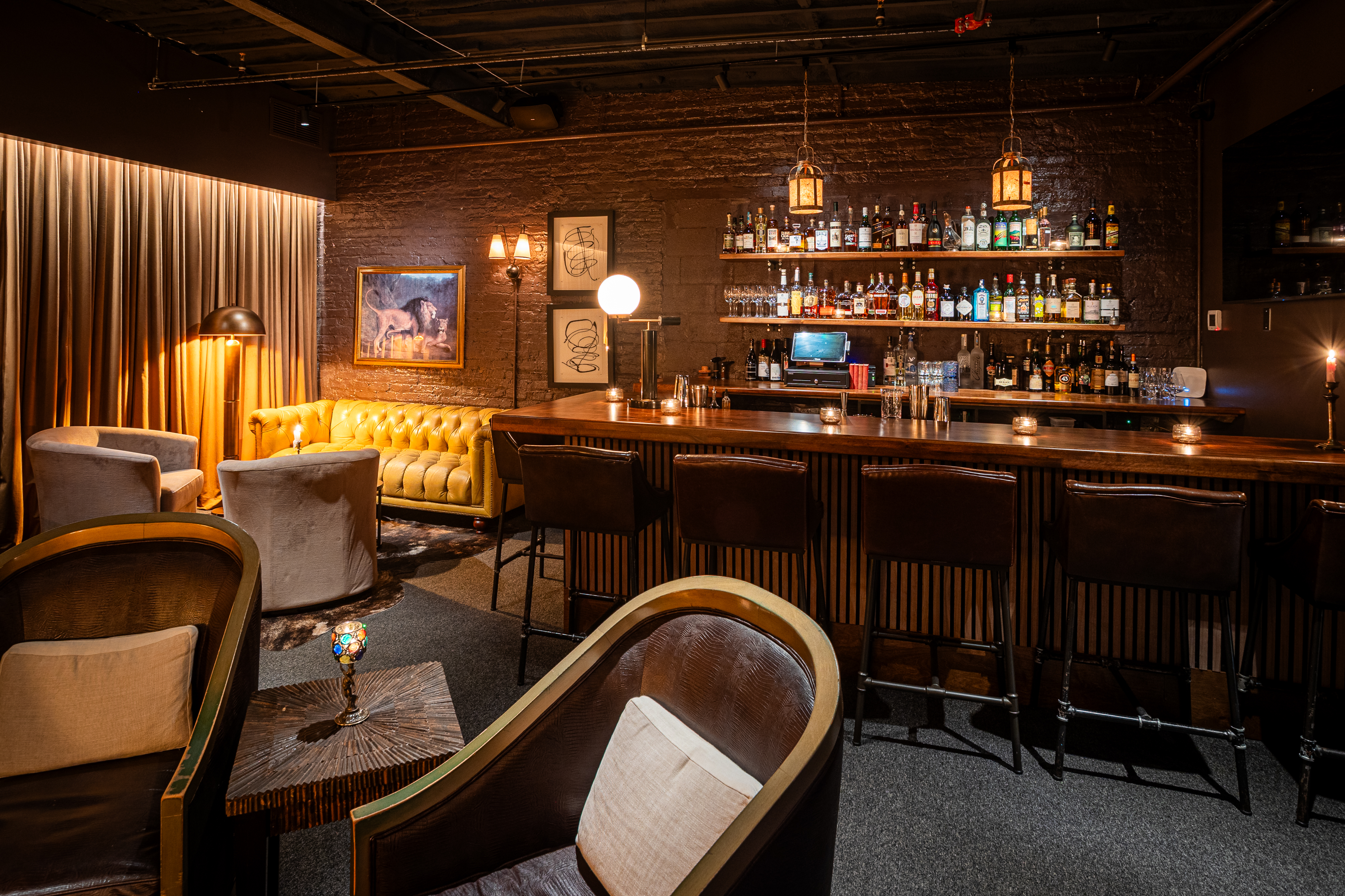 a bar with shelves of liquor and chairs