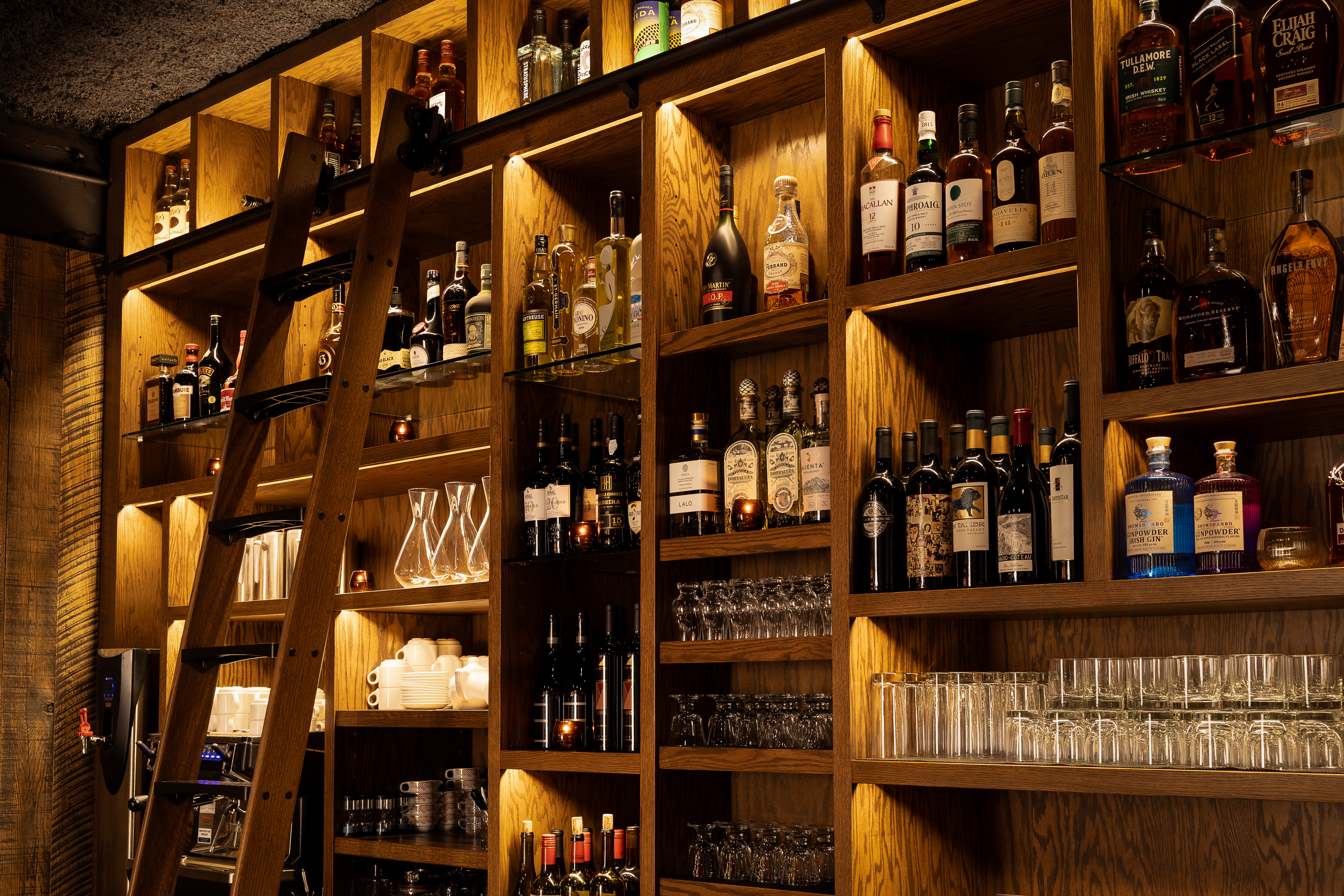 a shelf with bottles and glasses