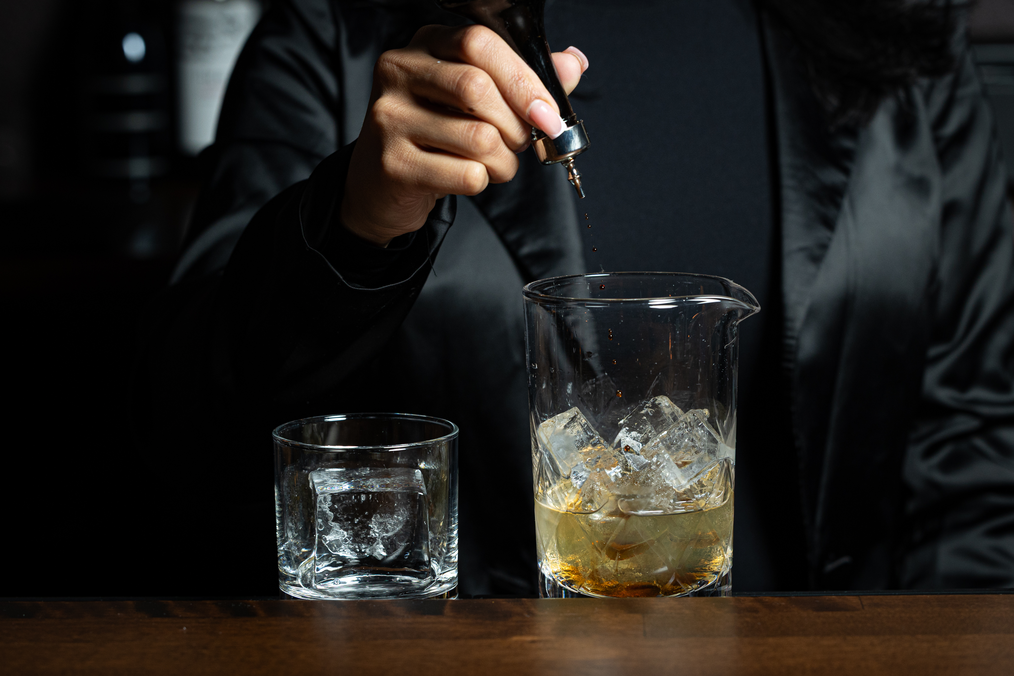 a person pouring liquid into a glass