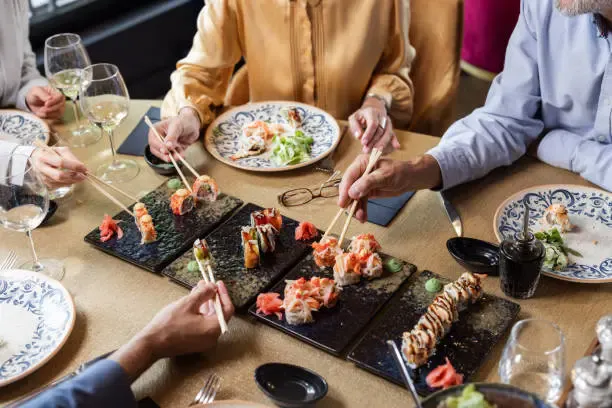 a group of people eating sushi
