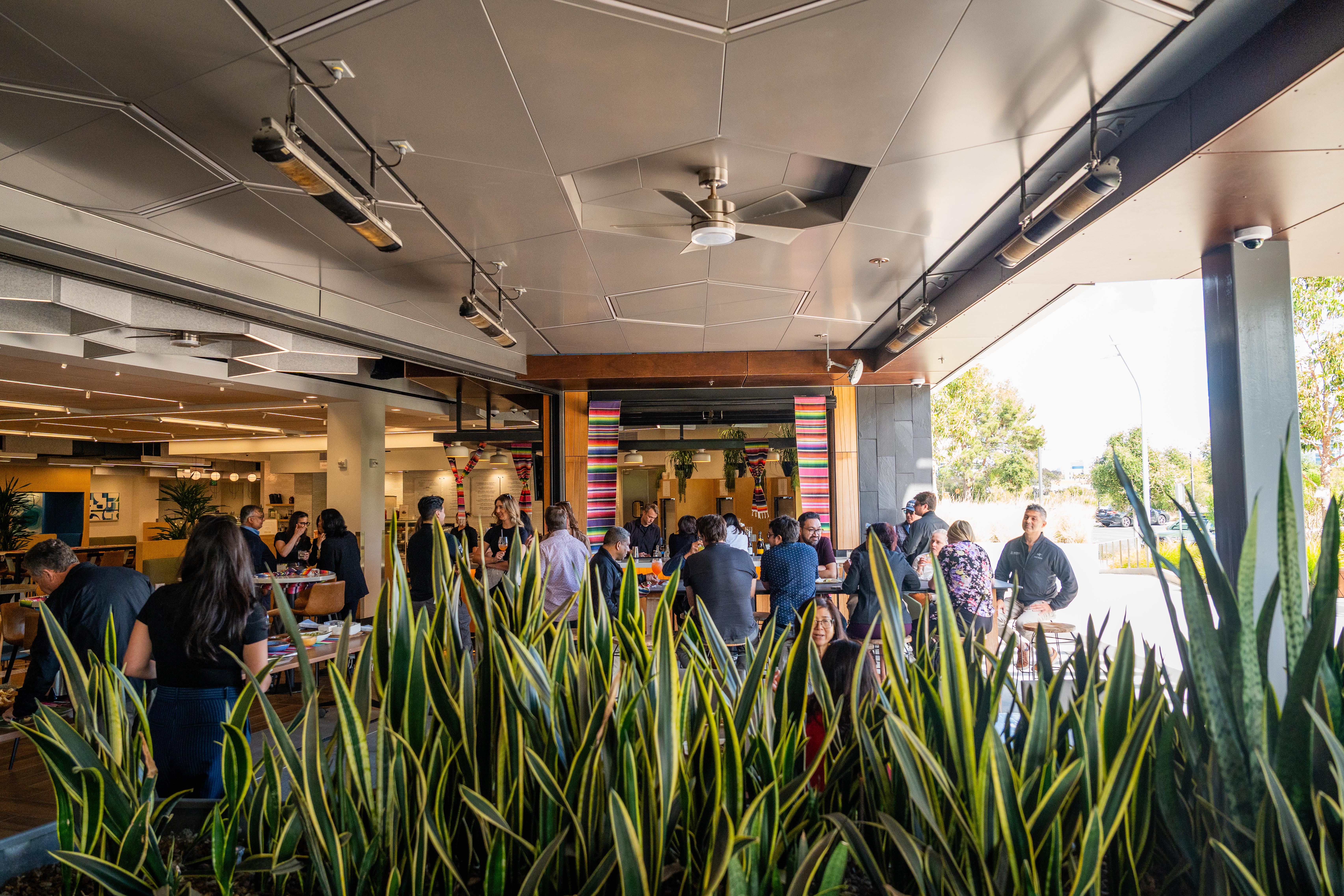 Guests gathering throughout Joya Kitchen's indoor-outdoor private event space.