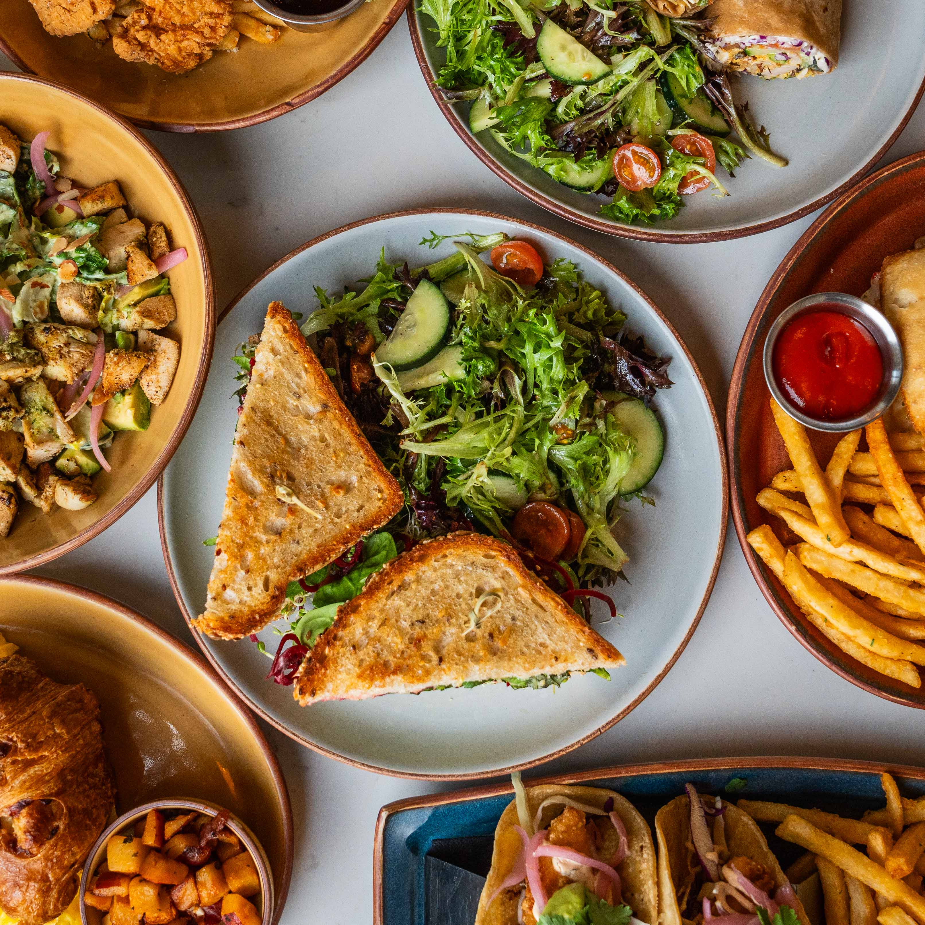 Variety of colorful Joya Kitchen dishes arranged across a dining table.