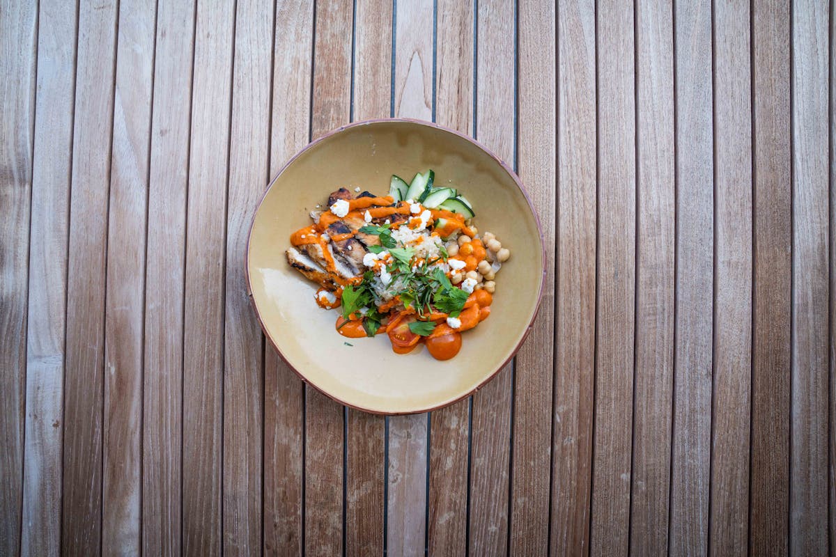 a slice of pizza sitting on top of a wooden fence