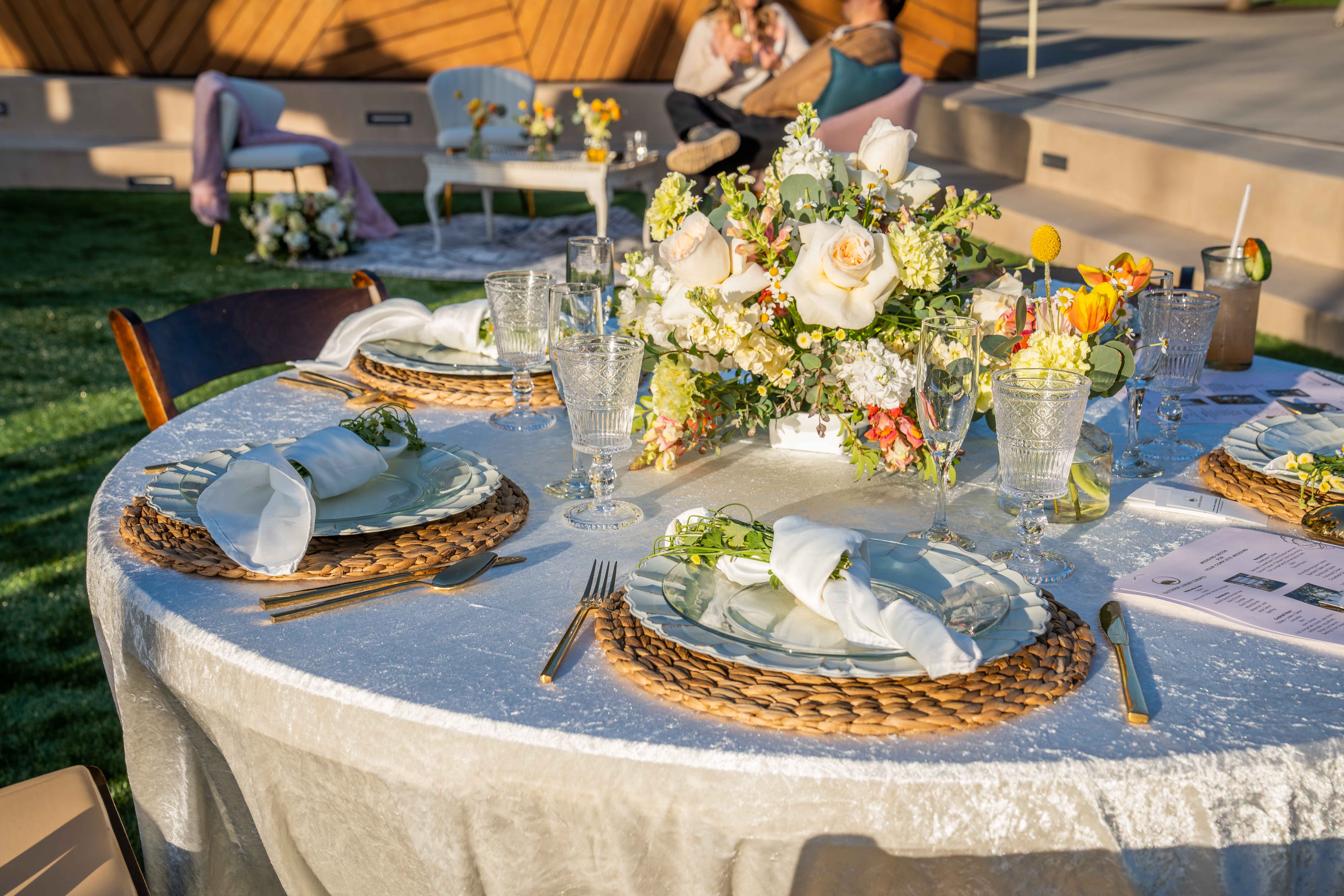 Outdoor dinner table with white flowers and place settings at Joya Kitchen.