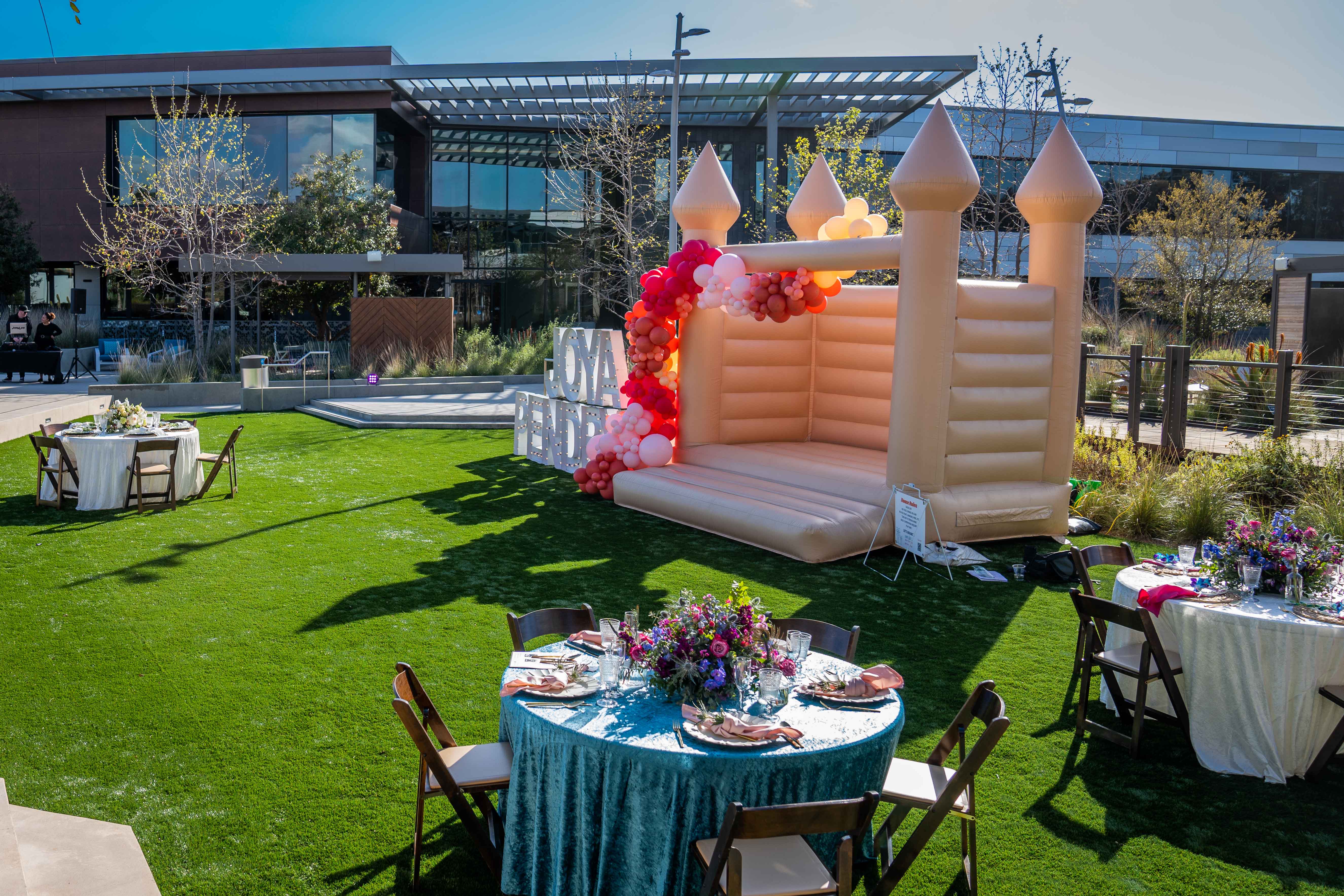 a couColorful outdoor celebration table with bright flowers and place settings at Joya Kitchen.ple of lawn chairs sitting on top of a picnic table