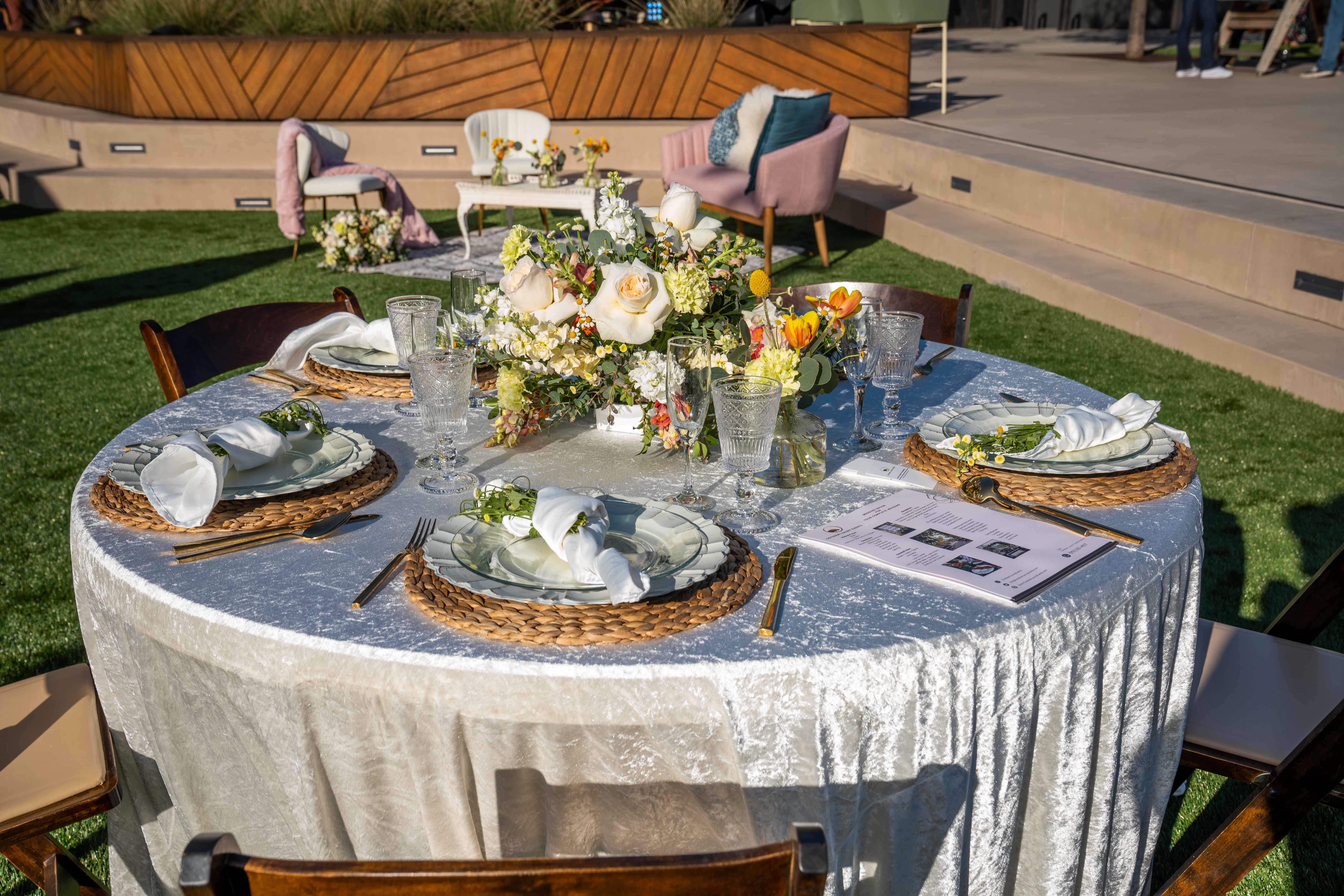Elegant round dinner table with white flowers at an outdoor Joya Kitchen event.