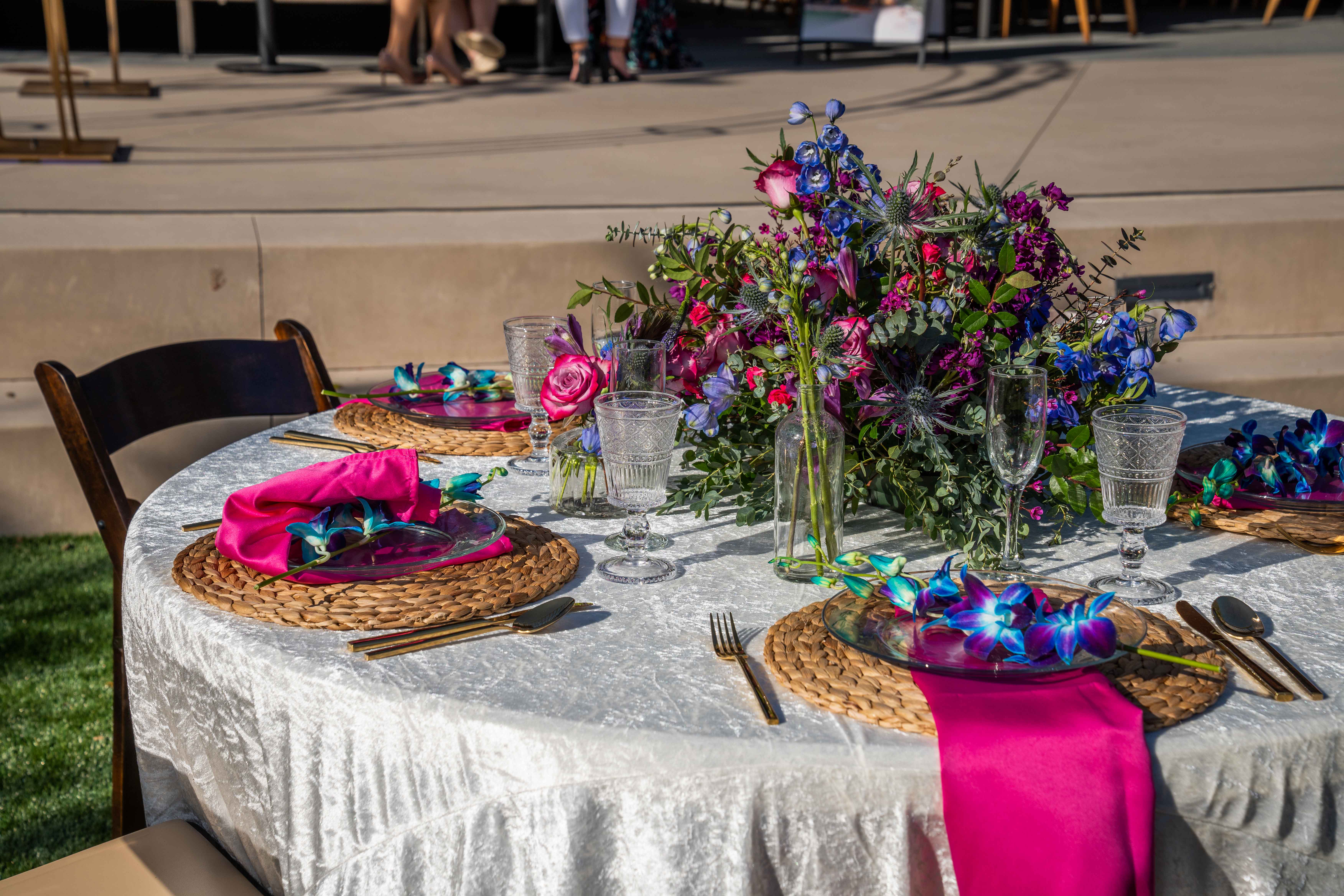 Round outdoor event table with bright flowers and place settings at Joya Kitchen.