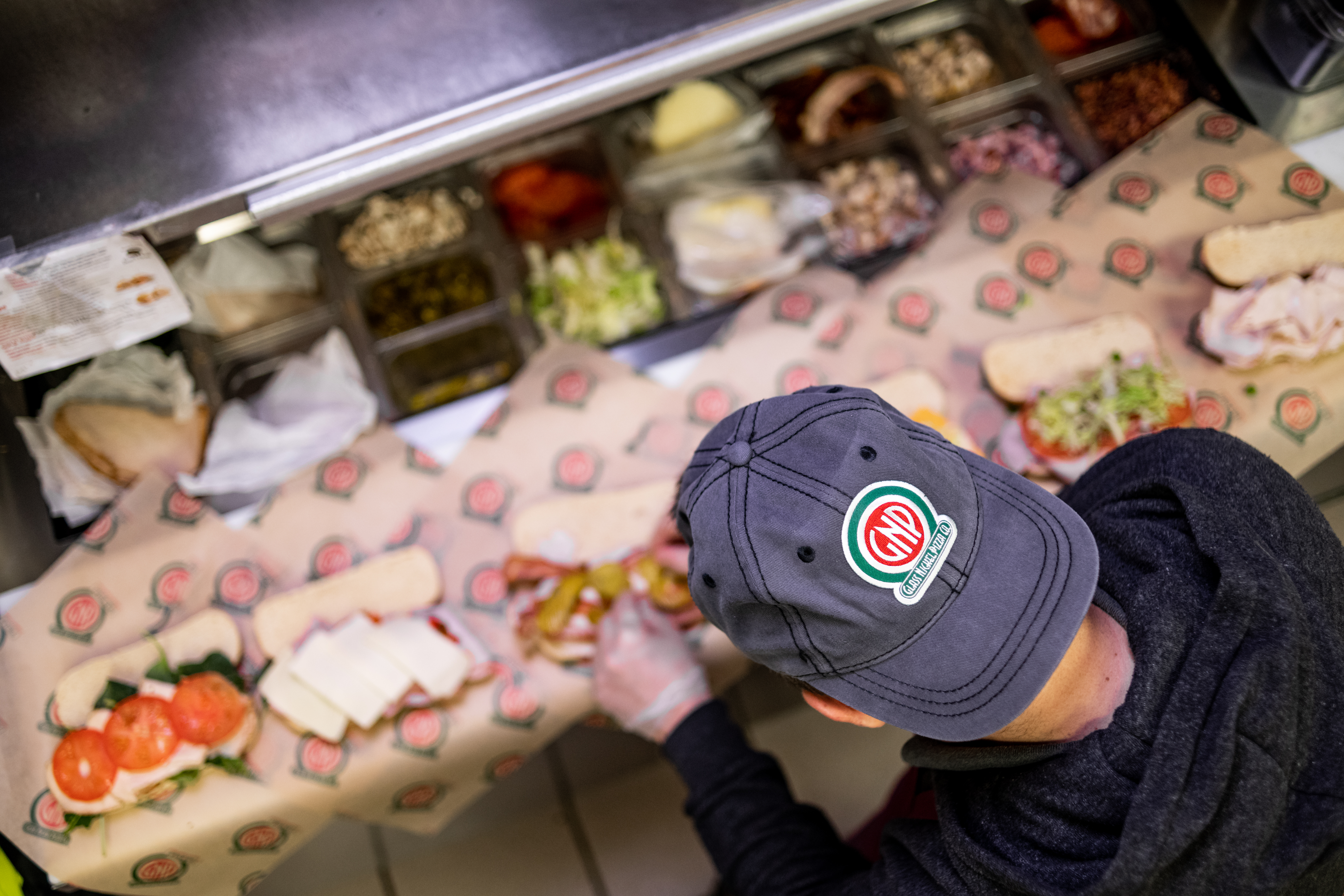 a woman holding a stack of pizza boxes