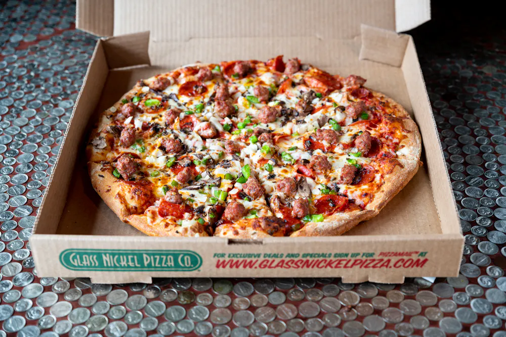 a woman holding a stack of pizza boxes