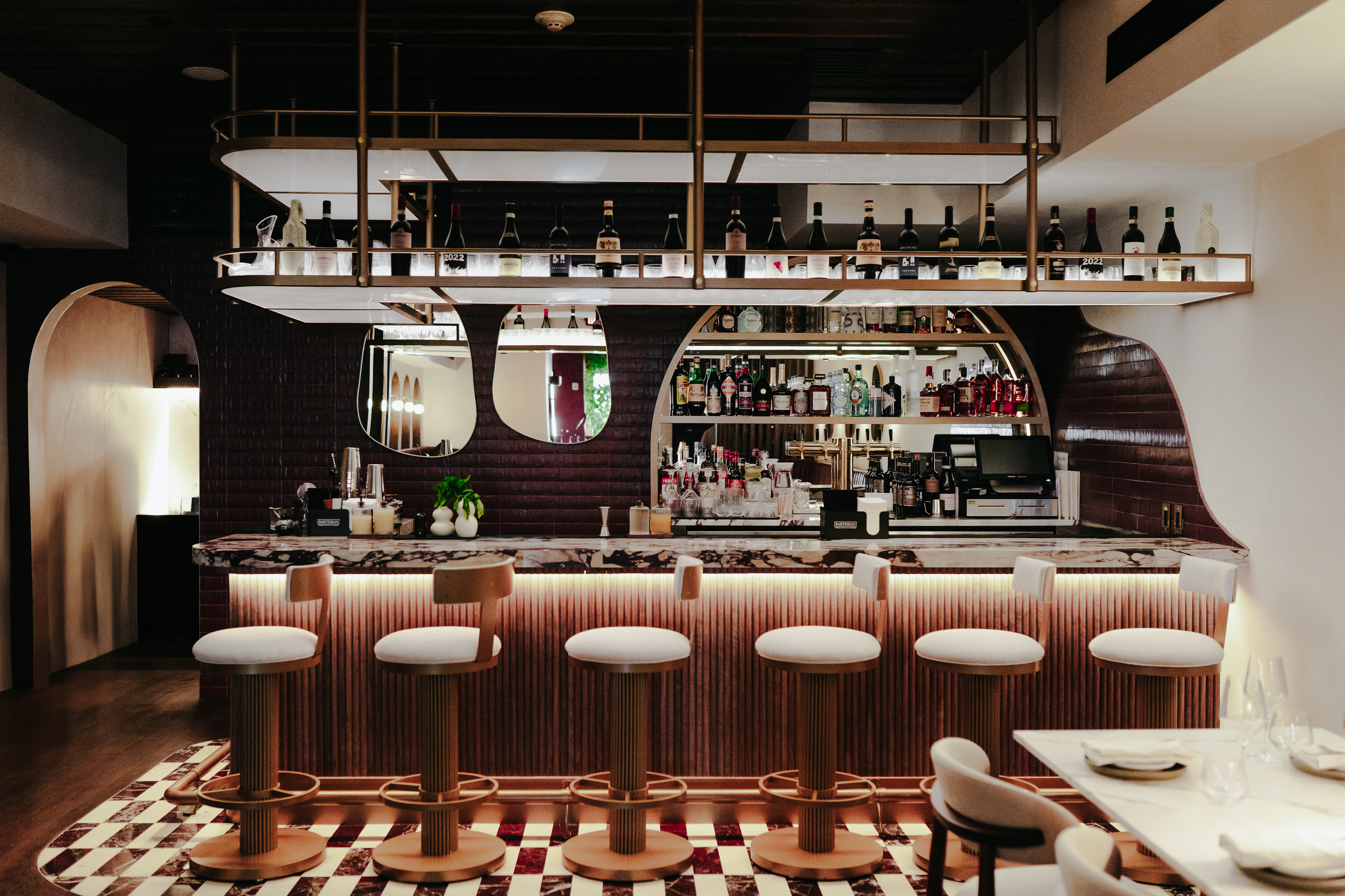 a bar with a row of stools and a counter