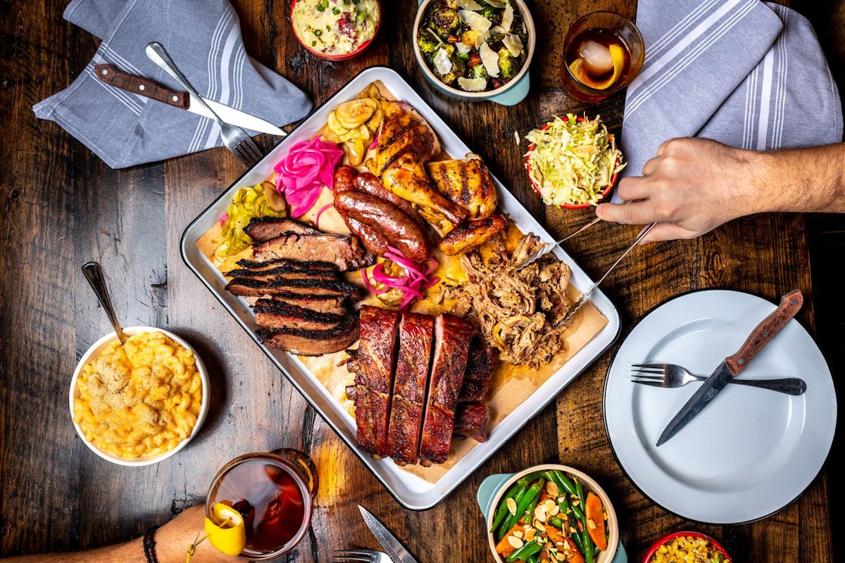 a person holding a bunch of food on a table